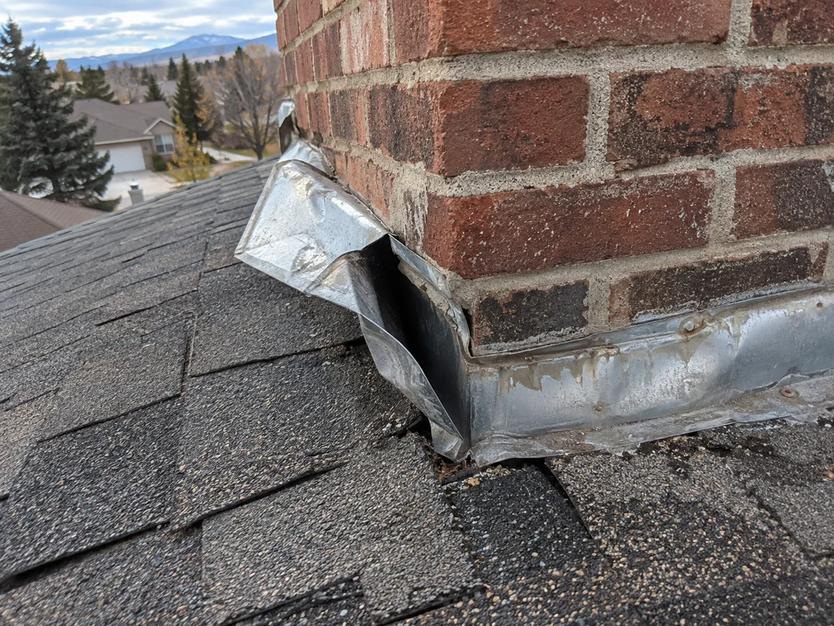 Bent chimney flashing pulled loose by high wind